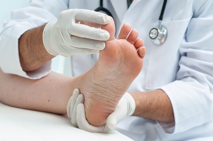 Dermatologist examines the patient's leg